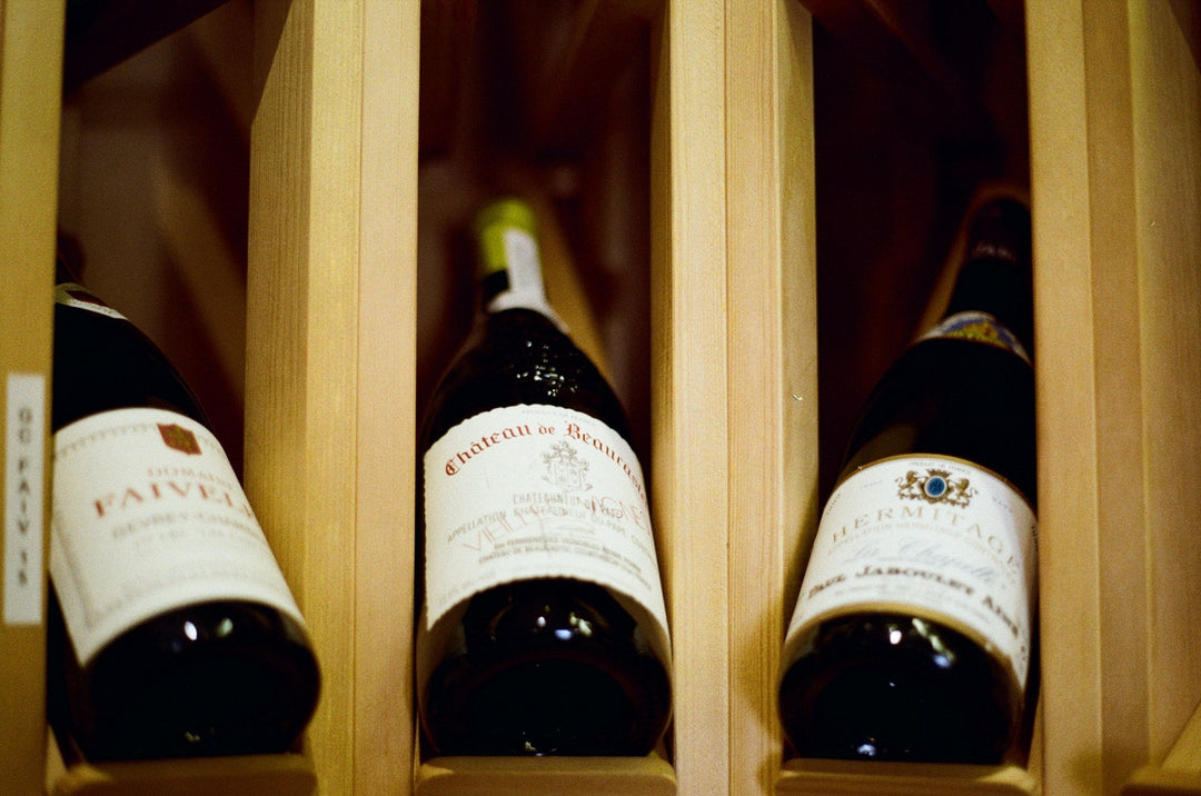Bottles of fine wine stored in a wooden cellar rack