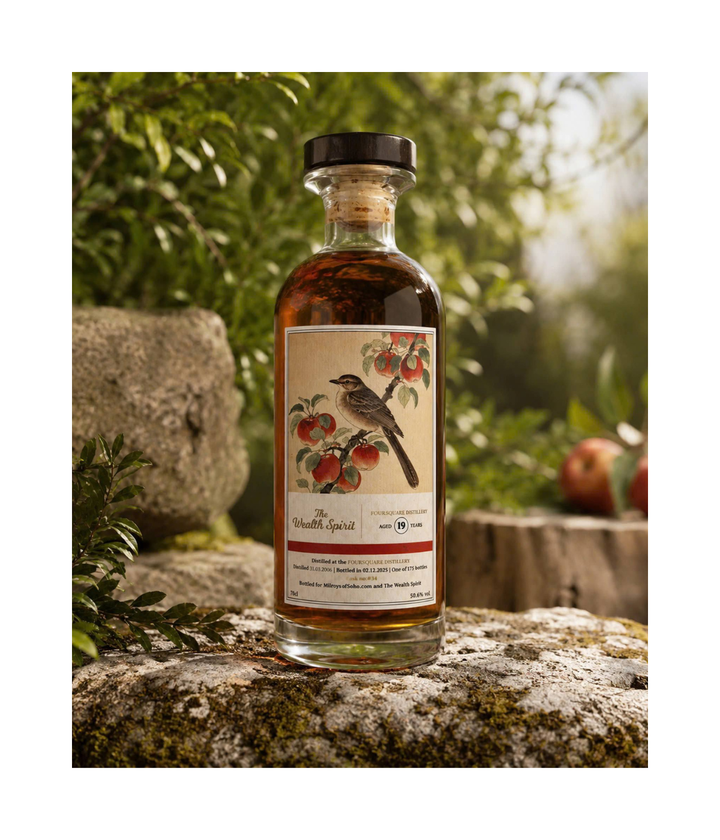 Bottle of rum with a decorative label featuring an apple tree and bird, set against a natural background.