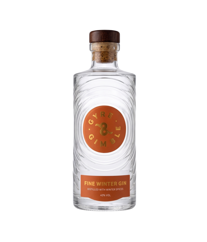 A clear glass bottle of Gyre &amp; Gimble Winter Gin with a cork stopper, featuring a textured clear label with a prominent orange circular logo and a matching orange label band at the bottom.