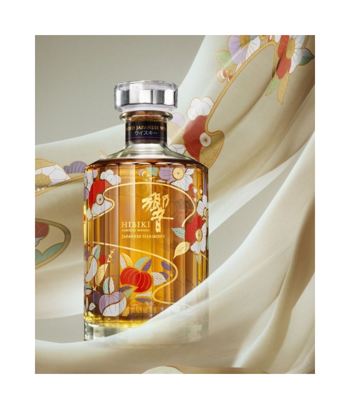 A bottle of Hibiki Chiso whisky with ornate floral and traditional Japanese artwork on the glass, set against a flowing cream-colorued fabric backdrop.